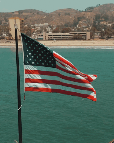 american-flag-waving-beach-view-g2ppz2ktvwxd7uj6.gif