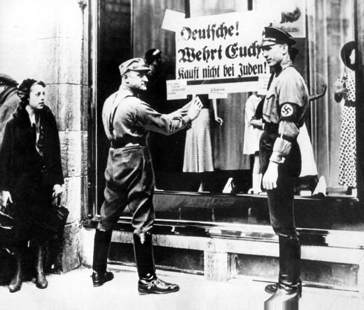 a-member-of-the-sa-posts-a-sign-on-a-jewish-shop-urging-germans-not-to-buy-from-jews.jpg