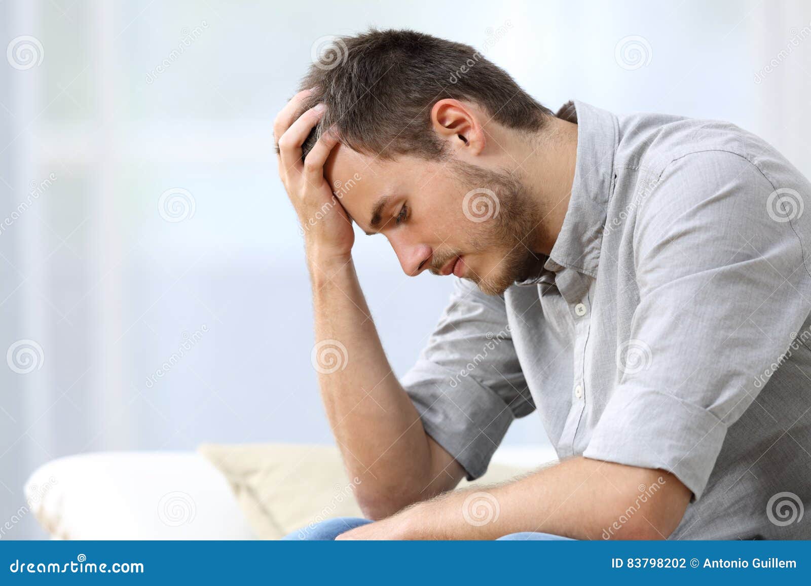 sad-man-sitting-couch-home-side-view-hand-head-living-room-83798202.jpg