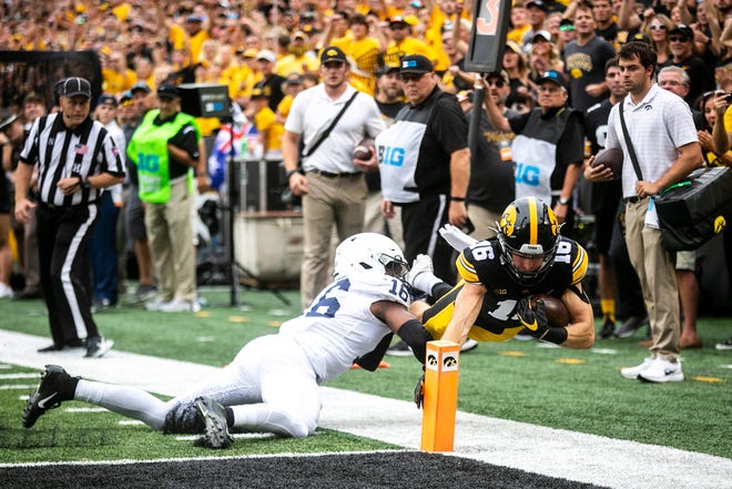 Iowa wide receiver Charlie Jones, right, scores a touchdown as Penn State safety Ji'Ayir Brown defends at Kinnick Stadium.